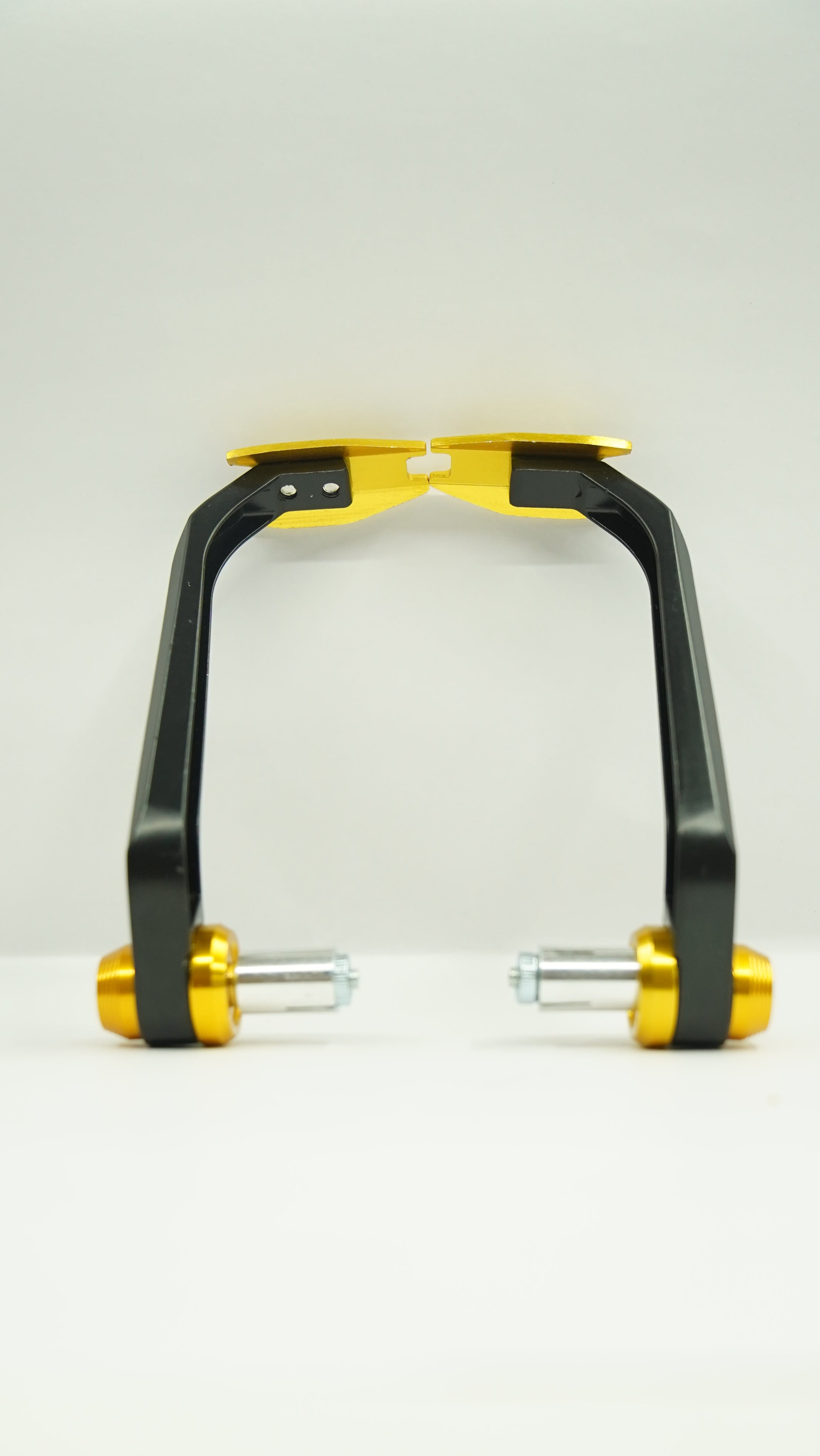 A pair of carbon metal lever guards with a black and gold finish, designed for motorcycle brake and clutch levers.